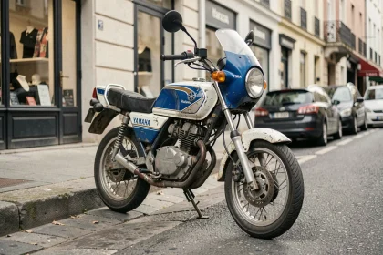 Yamaha TZR 50cc vintage garée dans une rue urbaine européenne, carénage bleu et blanc patiné avec décalcomanies fanées